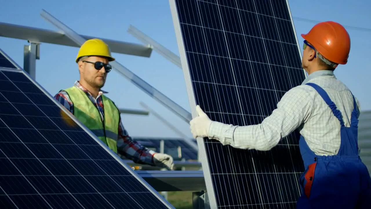 Installers fitting solar panels onto a frame