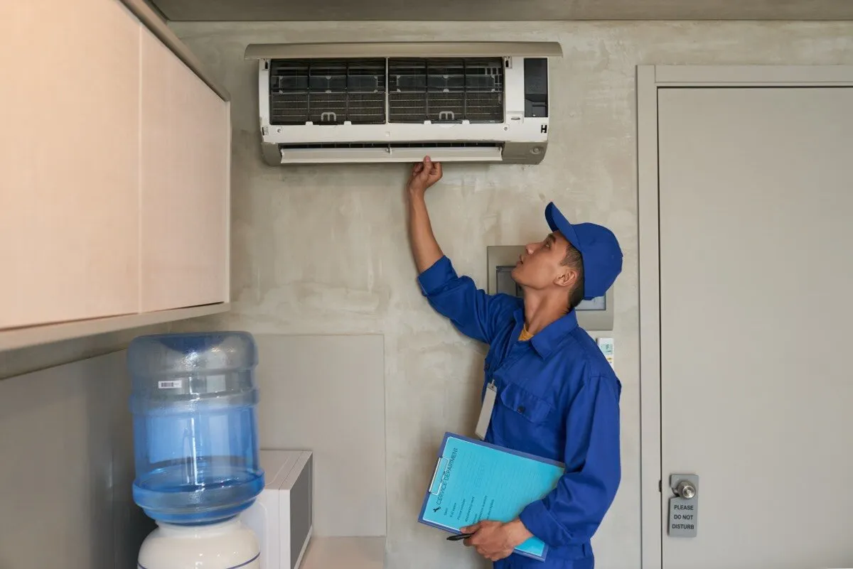 Wall-mounted split air conditioner being inspected